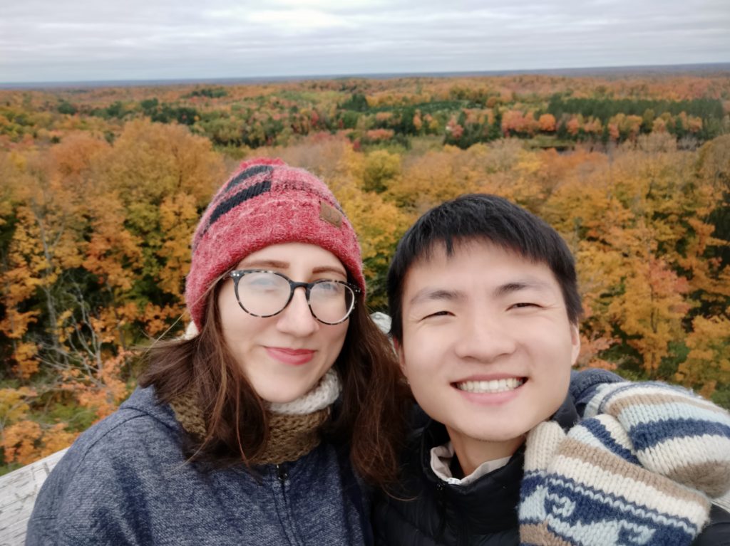 Girl and boy with autumn trees in the background